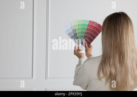 Donna con la vernice chip scelta colore per la parete interna. Design degli interni Foto Stock