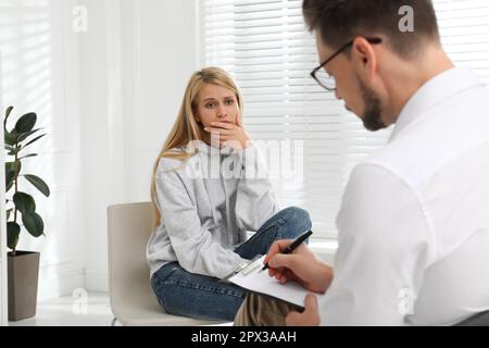 Psicoterapeuta che lavora con una giovane donna tossicodipendente in ambienti chiusi Foto Stock