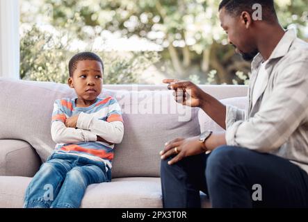 Non si può comportarsi così. un ragazzino che viene scoldato a suo padre a casa Foto Stock