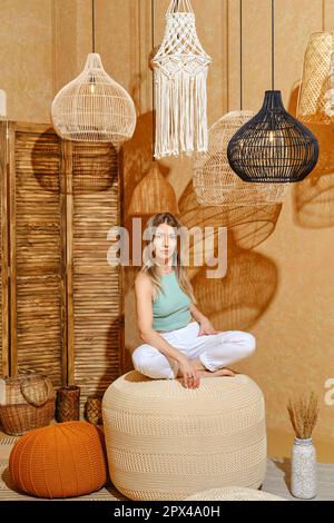 Aromaterapia. Donna anziana seduta su sgabello imbottito in un ambiente rilassante. Foto Stock