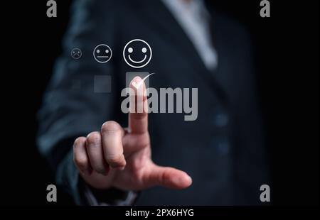 Uomo d'affari che preme emoticon faccina sorridente sullo schermo virtuale Foto Stock