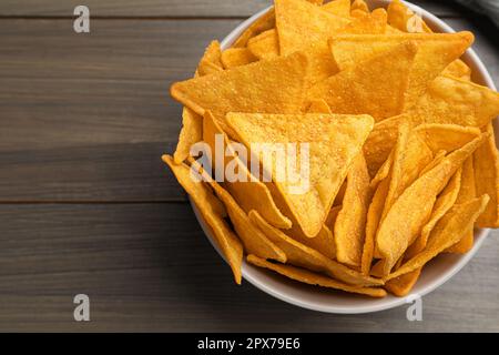 Tortilla chips (nachos) in ciotola su tavolo di legno, vista dall'alto Foto Stock