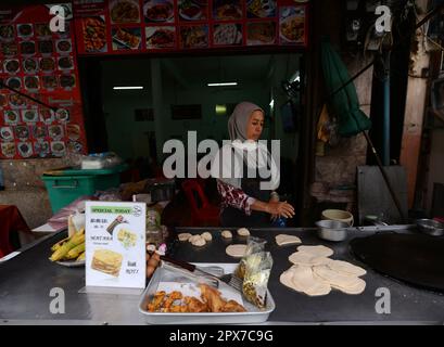 Una donna tailandese musulmana che prepara Roti in un piccolo ristorante vicino alla moschea Haroon a Bangkok, Thailandia. Foto Stock