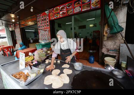 Una donna tailandese musulmana che prepara Roti in un piccolo ristorante vicino alla moschea Haroon a Bangkok, Thailandia. Foto Stock