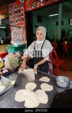 Una donna tailandese musulmana che prepara Roti in un piccolo ristorante vicino alla moschea Haroon a Bangkok, Thailandia. Foto Stock