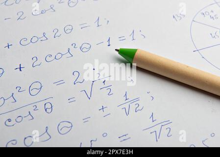 Carta con calcoli matematici scritti e penna, primo piano Foto Stock