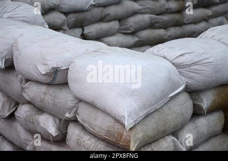 Sfondo di molti sacchi di sabbia sporca per la difesa contro le inondazioni. Barricata protettiva per uso militare. Bel bunker tattico Foto Stock