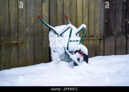 Carriola a un muro di neve in inverno. Foto Stock