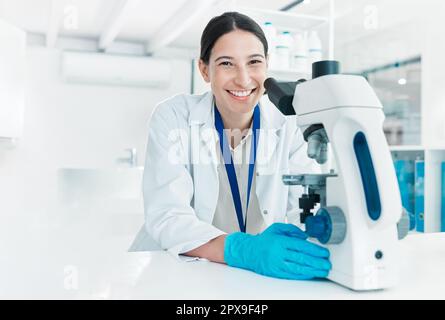 Im sta per finire il mio caso di ricerca. Ritratto di un giovane scienziato utilizzando un microscopio in laboratorio. Foto Stock