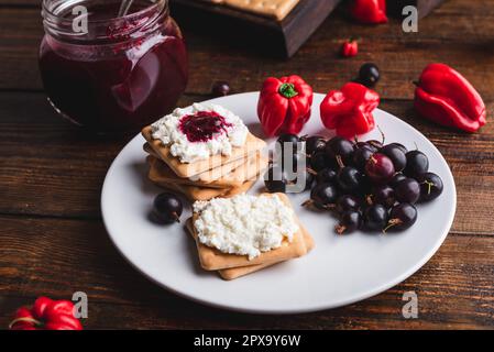 Cracker con uva spina e peperone rosso Habanero confettura e ricotta Foto Stock