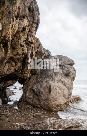 Alcune scogliere sulla spiaggia, in mare, con un buco in loro. Foto Stock