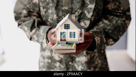 Programma SCRA. Esercito militare uomo in uniforme che tiene Nuova Casa Foto Stock