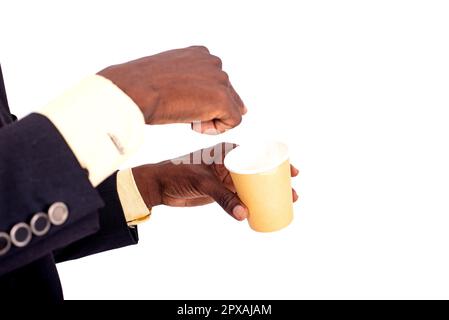 Vista ritagliata della mano di un uomo d'affari che punta il dito verso una tazza di carta di caffè. Foto Stock