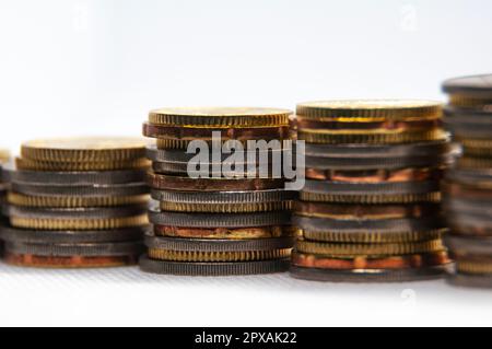 Primo piano delle monete su sfondo bianco con spazio personalizzabile per testo o idee. Concetto di business e di investimento. Foto Stock