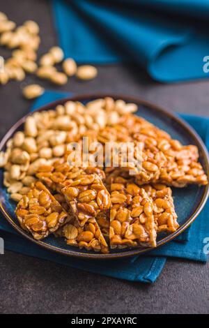 Arachidi dolci friabili. Gustose arachidi in caramello sul piatto. Foto Stock