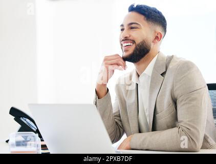 Im così fiero di me. un bel giovane uomo d'affari seduto da solo in ufficio e utilizzando il suo computer portatile. Foto Stock