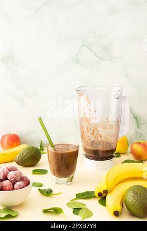 Colazioni salutari, frullati salutari e deliziosi con fragole e banane surgelate e avocado, proteina di piselli e verdure miste, frullato bicchiere mixer Foto Stock