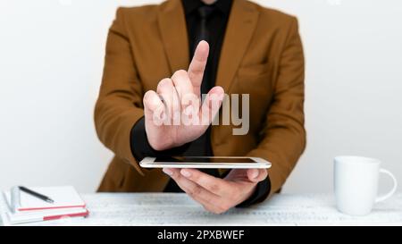 Uomo d'affari in una giacca marrone seduto a un tavolo con un telefono cellulare Foto Stock
