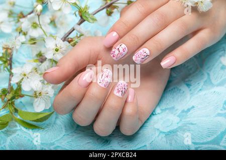 Manicure primaverile per la sposa in toni delicati con fiori. Progettazione di chiodi. Foto Stock