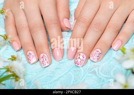 Manicure primaverile per la sposa in toni delicati con fiori. Progettazione di chiodi. Foto Stock