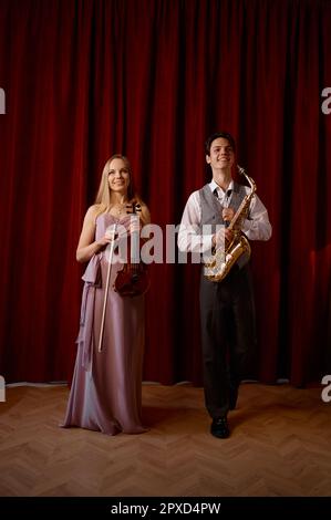 Sax uomo e donna fiddler duetto. Duo musicale jazz band sul palco Foto Stock