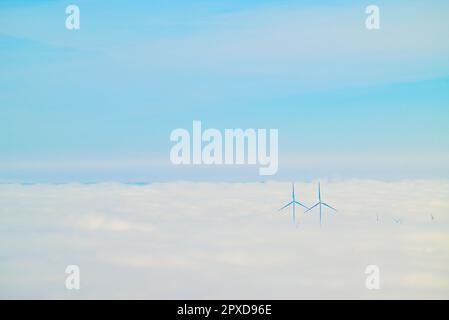 I due mulini a vento in nubi dense contro un cielo nuvoloso Foto Stock