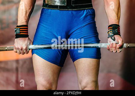 primo piano mani powerlifter in polsi avvolge il barbell con gesso da palestra applicato Foto Stock