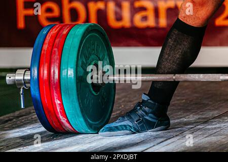 deadlift in gara powerlifting, gambe atleta powerlifter e barbell con piatti Foto Stock