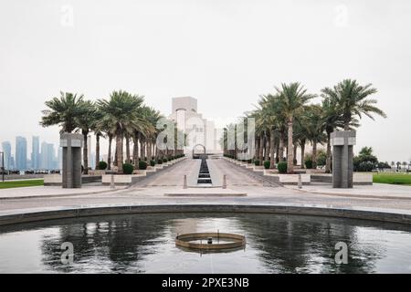 Doha, Qatar - Aprile 2023, l'iconico edificio del Museo di Arte Islamica progettato dall'architetto I.M. Il PEI si trova sulla Doha Corniche con le file di palme Foto Stock