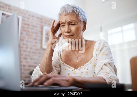 Questo non faceva parte del pacchetto pensionistico. una donna anziana che guarda stressata mentre usa un notebook a casa. Foto Stock