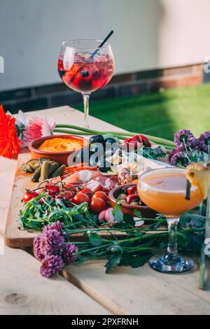 Un mix di spuntini e antipasti diversi su un asse di legno Foto Stock