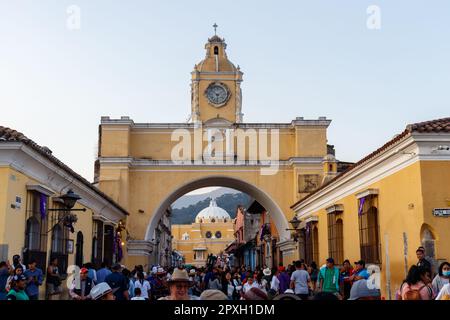 Antigua Guatemala 5 aprile 2023: Paesaggio urbano della strada principale e arco giallo di Santa Catalina con un sacco di persone che camminano intorno a rovinare semana santa Foto Stock