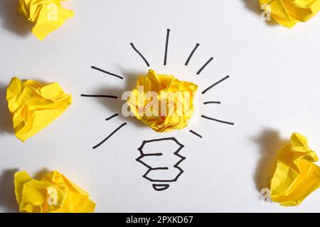 Idee creative e concetto di innovazione. Carta colore giallo palla scarto con simbolo lampadina Foto Stock