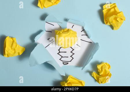 Idee creative e concetto di innovazione. Carta colore giallo palla scarto con simbolo lampadina Foto Stock