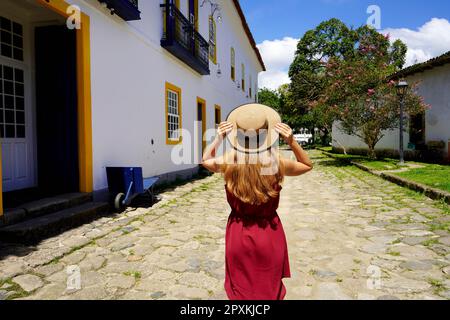 La ragazza viaggiatore cammina per le strade nella storica città coloniale conservata di Paraty, Brasile Foto Stock