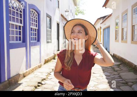 Donna sorridente alla moda in visita alla città latino-americana. Copiare lo spazio vuoto per il testo. Foto Stock