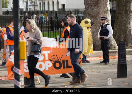 Gli agenti di polizia parlano con gli attivisti Just Stop Oil a Westminster, nel centro di Londra. Foto Stock