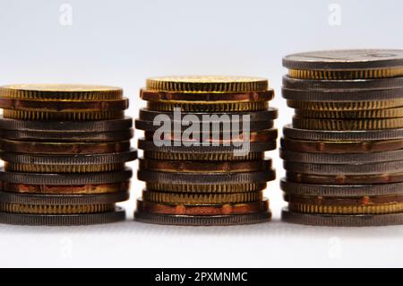 Primo piano delle monete su sfondo bianco con spazio personalizzabile per testo o idee. Concetto di business e di investimento. Foto Stock