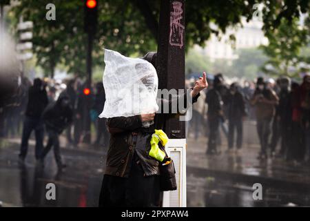 (NOTA DELL'EDITORE : immagine raffigura la profanità)Un protester con una plastica sulla testa si confronta con la polizia mentre l'acqua dei cannoni cerca di disperdere la folla. La giornata del lavoro in Francia è stata segnata da centinaia di arresti, nonché da numerosi poliziotti e manifestanti feriti durante gli scontri. A Parigi, una marcia pacifica e festosa si contrapponeva a una marcia più radicale dove si sono verificati violenti scontri. Entrambi partirono da Place de Republique a Place de la Nation. I manifestanti restano fermi nella lotta contro la nuova legge Pens che mira ad innalzare l’età. (Foto di Telmo Pinto/SOPA Images/Sipa USA) Foto Stock