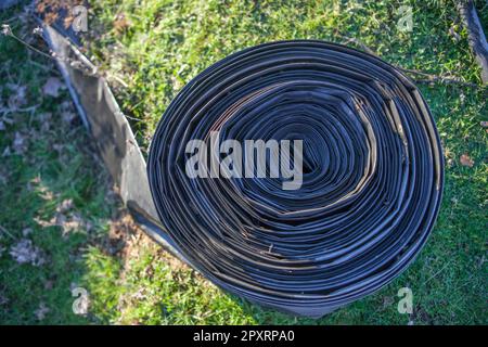 Nastro arrotolato di sistema di tubi flessibili per irrigazione. Vista dall'alto Foto Stock