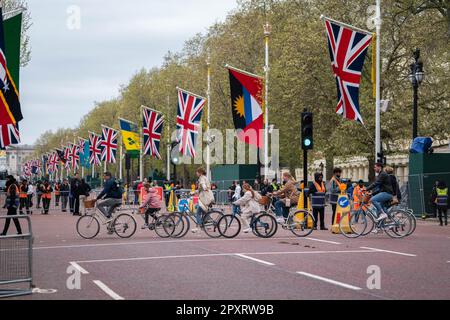 Londra Regno Unito. 2 maggio 2023. Ciclisti che attraversano il Mall fiancheggiato da Union Jacks e bandiere del Commonwealth con 4 giorni rimanenti fino all'incoronazione di re Carlo III e della regina Camilla il 6 maggio presso l'Abbazia di Westminster . L'incoronazione dovrebbe attirare grandi folle per guardare la processione della carrozza reale. Credit: amer Ghazzal/Alamy Live News Foto Stock