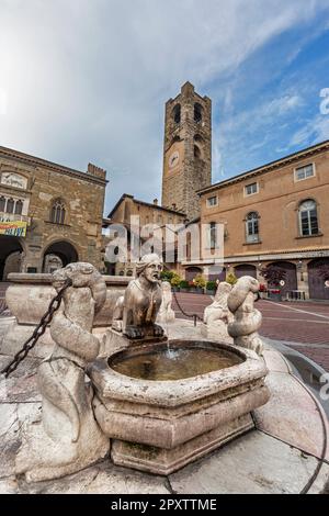 Torre Civica del 11th° secolo, chiamata Campanone nel centro storico. Palazzo della ragione (a sinistra) e Palazzo del Podesta (a destra) con fontana in Piazza Vecchia Foto Stock