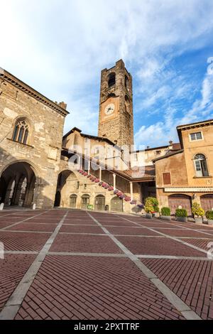 Torre Civica del 11th° secolo chiamata anche Campanone nel centro storico. Palazzo della ragione (a sinistra) e Palazzo del Podesta (a destra) nella medievale Piazza Vecchia Foto Stock