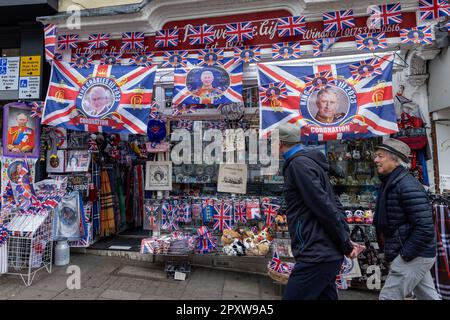 Windsor, Regno Unito. 2nd maggio, 2023. I membri del pubblico passano un negozio di articoli da regalo che mostra souvenir dell'incoronazione con immagini di Re Carlo III L'incoronazione di Re Carlo III si terrà presso l'Abbazia di Westminster il 6 maggio. Credit: Notizie dal vivo di Mark Kerrison/Alamy Foto Stock