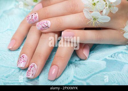 Manicure primaverile per la sposa in toni delicati con fiori. Progettazione di chiodi. Foto Stock