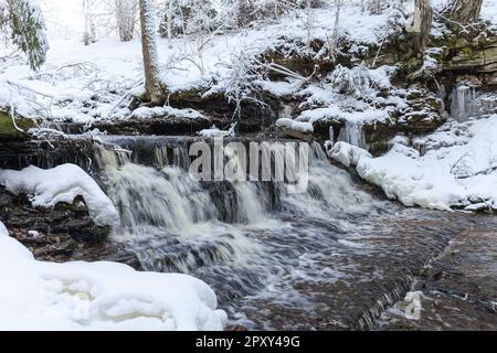 Piccola cascata Vasaristi in inverno, parco nazionale di Lahemaa, Estonia. Esposizione lunga Foto Stock