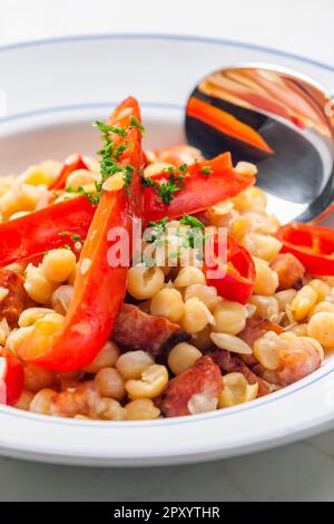 miscela di piselli gialli e pancetta servita con pepe rosso e peperoncino Foto Stock