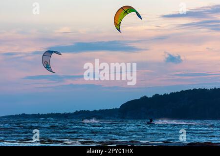 Gothenburg, Svezia - Ottobre 10 2021: Kiteboarders kitesurf al tramonto su una spiaggia . Foto Stock