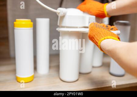 L'idraulico installa o cambia il filtro dell'acqua. Filtro acqua di ricambio Foto Stock