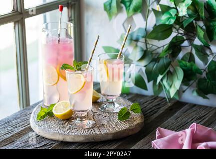 Limonata fredda e rinfrescante con cubetti di ghiaccio di limonata rosa, pronta per essere condivisa. Foto Stock